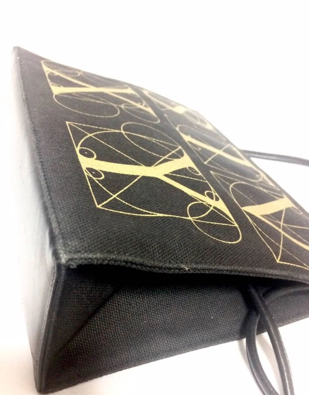 Vintage Paloma Picasso black canvas and leather combo shoulder bag with golden A B C D E F and S T V X Y letter print.