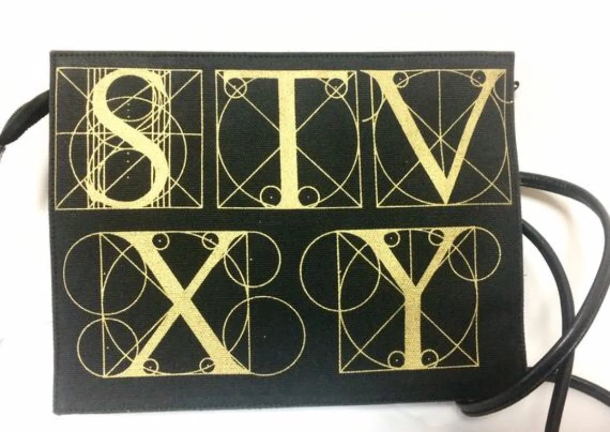 Vintage Paloma Picasso black canvas and leather combo shoulder bag with golden A B C D E F and S T V X Y letter print.